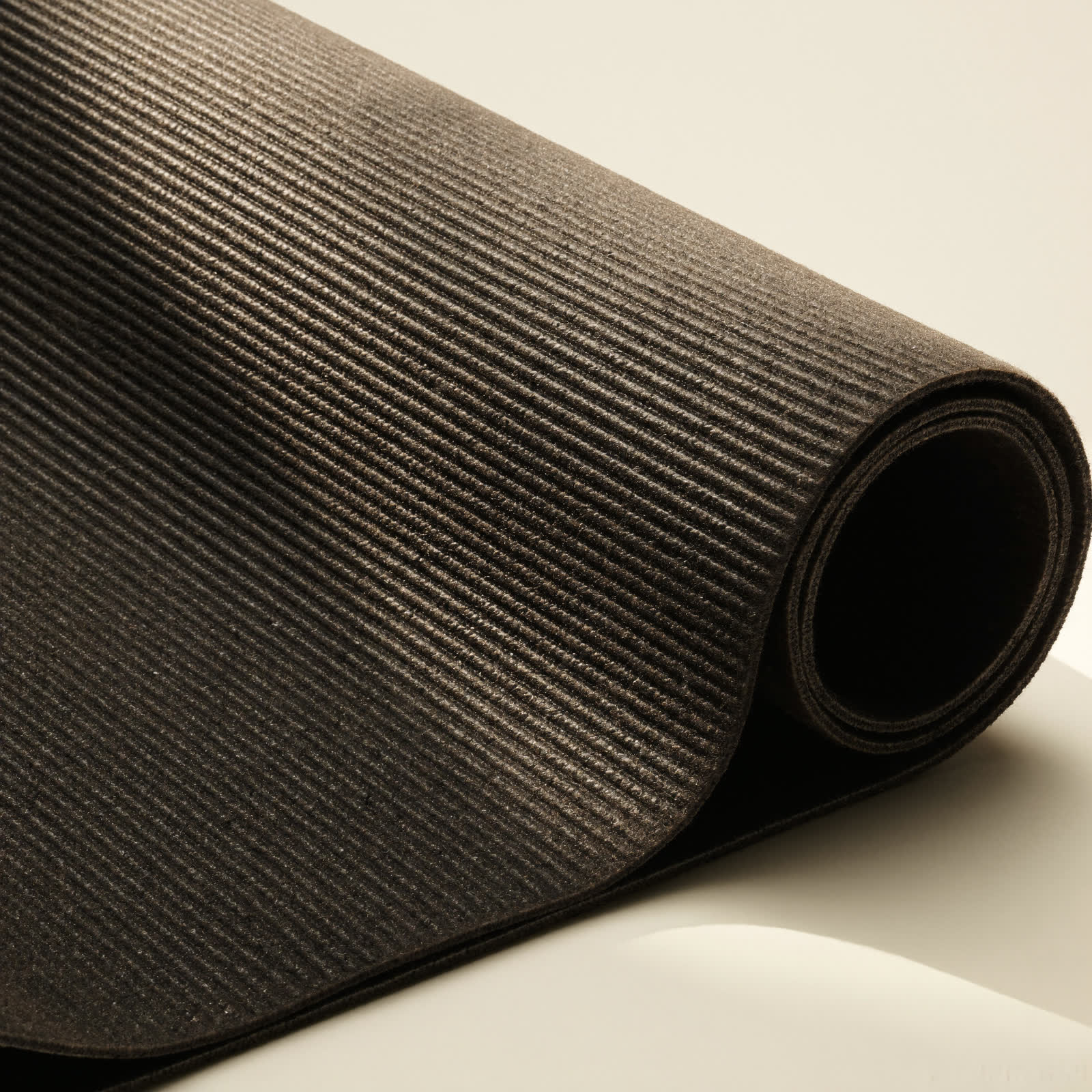 Detail shot of hands rolling a Manduka PRO mat